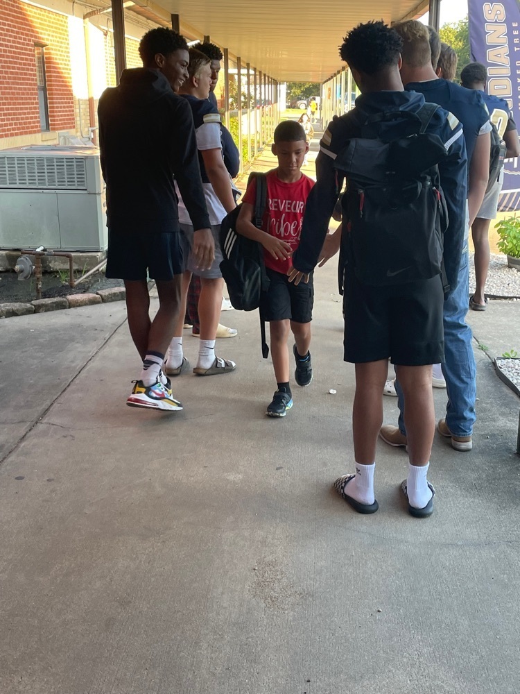 Football team greets elementary students.